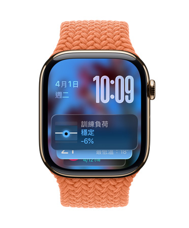 以金色鈦金屬打造的 Apple Watch，搭配橘紅色編織錶帶，錶面左上角顯示日期、右上角顯示以數字堆疊呈現的時間，底部顯示訓練負荷小工具，都以 Liquid Glass 的半透明風格呈現