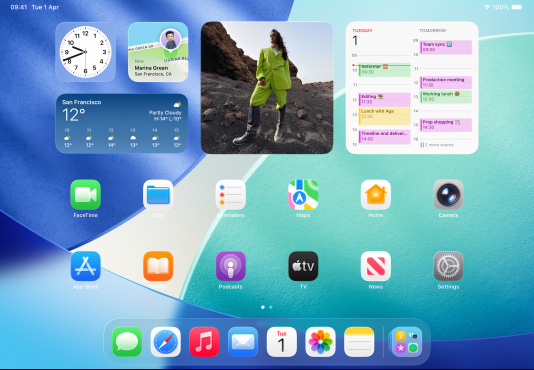 iPad, three models, landscape orientation, with centre model in front of two others, Apple Pencil magnetically attached to top of centre model, centre screen showing the Home Screen featuring colourful app icons with Liquid Glass effect, left screen showing the app, right screen showing Home Screen with files fanning out from the Dock