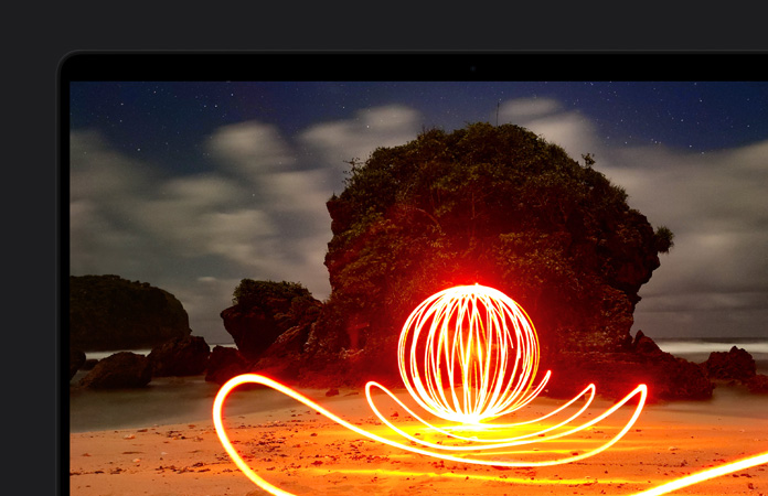 MacBook Pro che mostra l’immagine di un’installazione artistica luminosissima posizionata su una spiaggia, per evidenziare il contrasto del display reso possibile dalla gamma dinamica estrema